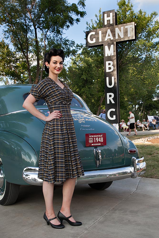 vintage car parked in front of replica sign for red's giant hamburg