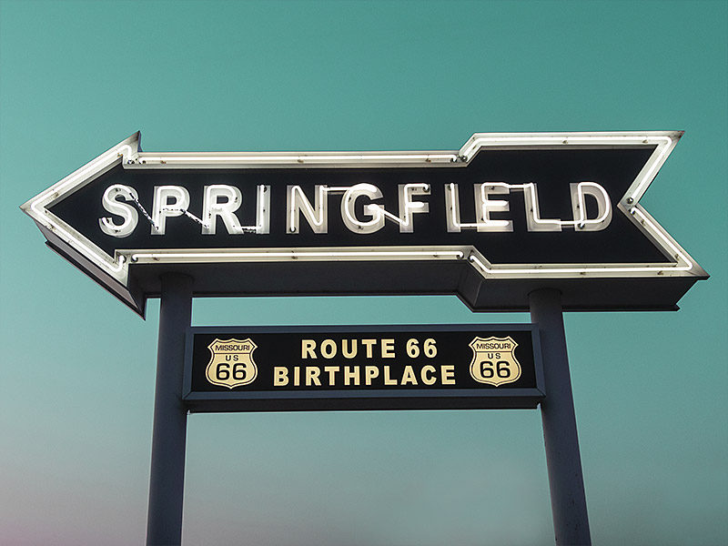 neon arrow-shaped sign with Springfield text inside and Route 66 shields